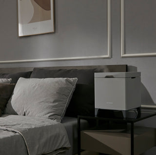 Carepod Cube X50 Warm + Cool Mist Stainless Steel Humidifier on a bedside table