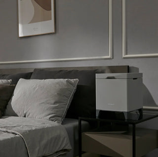 Carepod Cube X50 Warm + Cool Mist Stainless Steel Humidifier on a bedside table
