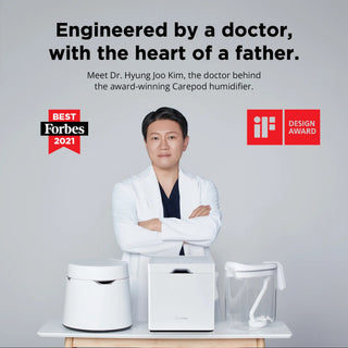 Person in a white lab coat standing behind three Carepod humidifiers with arms crossed