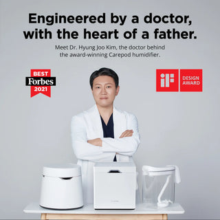 Person in a white lab coat standing behind three Carepod humidifiers with arms crossed